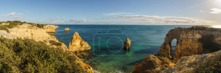 Golden cliffs at the coastline of the Atlantic Ocean with famous two arch rock formation Elephant Rock near the Cave of Benagil, Algarve, Portugal