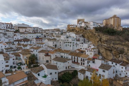 Vista sobre el típico pueblo andaluz con casas blancas y calle con viviendas construidas en salientes rocosos, Setenil de las Bodegas, Andalucía, España