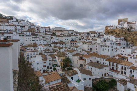 View over typical andalusian village with white houses and street with dwellings built into rock overhangs, Setenil de las Bodegas, Andalusia, Spain