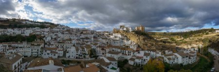 Blick auf andalusisches Dorf mit weißen Häusern und Straße mit in Felsüberhänge eingebauten Wohnhäusern, Setenil de las Bodegas, Andalusien, Spanien