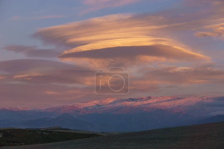 Landscape of Sierra Nevada mountains with lenticular clouds during sunset near Granada, Andalusia, Spain