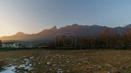 Rural scene of the Po Valley with mountain skyline of the Alps illuminated with golden sunlight during sunset, Veneto, Italy
