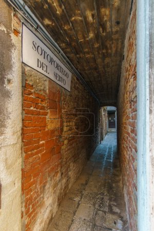 El estrecho callejón Sotoportego del Servo en Venecia, Véneto, Italia