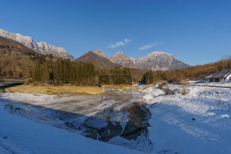 Leerer gefrorener Stausee im Winter in der Berglandschaft der Alpen, Barcis, Friaul-Julisch Venetien, Italien