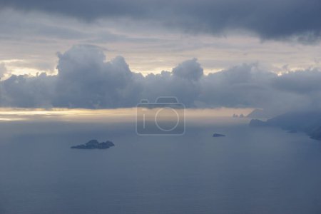 Blick auf die felsige Landschaft über das Meer entlang der Amalfiküste mit kleiner Insel, Provinz Salerno, Kampanien, Italien