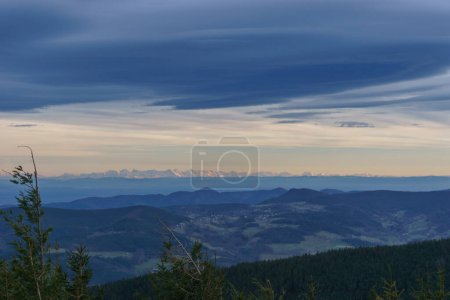 Evening view at Grand Brezouard over the Rhine Valley at mountain landscape of Vosges up to the distant Alps during winter, Alsace, France