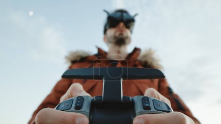 Téléchargez les photos : Pilot controlling fpv drone through virtual glasses - en image libre de droit