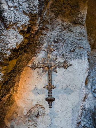 crucifijo colgado en un santuario en una cueva.