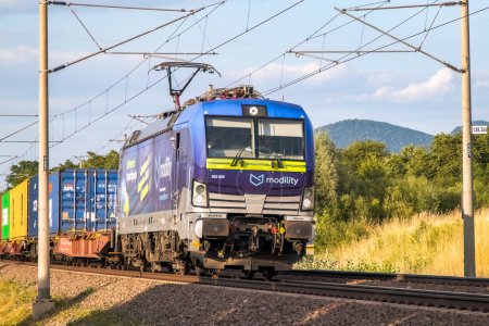 Foto de Dubnica nad Vahom, Eslovaquia - 4 de julio de 2023 - Tren de mercancías de la empresa de transporte alemana Modility en la línea ferroviaria eslovaca. - Imagen libre de derechos