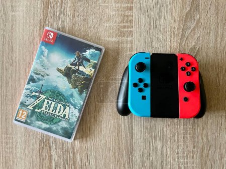 Photo for Prague, Czech Republic - May 11 2023: The Legend of Zelda: Tears of the Kingdom case and Nintendo Switch controller on wooden table. This is a sequel to the game Breath of the Wild - Royalty Free Image