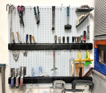 Foto de Pared blanca con juego de diferentes herramientas en un taller - Imagen libre de derechos