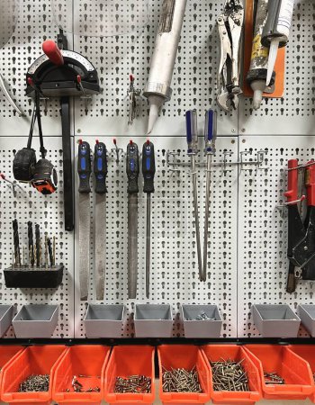 Photo for White pegboard wall with set of different tools in a workshop - Royalty Free Image
