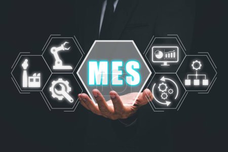 MES - Manufacturing Execution System concept, Businessman hand holding Manufacturing Execution System icon on virtual screen.