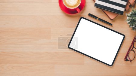 Photo for Office wooden desk with blank screen tablet, notebook, pen, eyeglass and cup of coffee, Top view flat lay with copy space. - Royalty Free Image