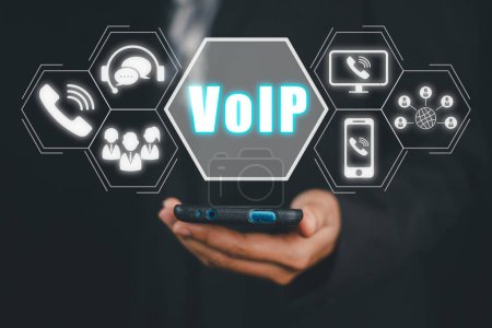 VoIP, Voice over IP Telekommunikationskonzept, Geschäftsmann Hand mit Smartphone mit VoIP-Symbol auf virtuellem Bildschirm.