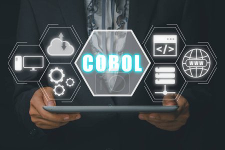 Foto de Cobol, Common Business Oriented Language, Persona de mano que sostiene la computadora de la tableta con el icono de cobol en la pantalla virtual. - Imagen libre de derechos