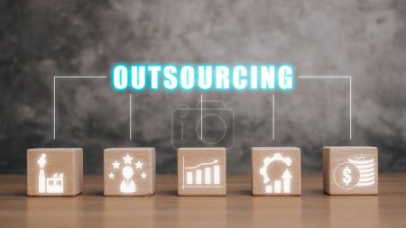Outsourcing Global Recruitment Business e internet concept, Bloque de madera en el escritorio con icono de outsourcing en la pantalla virtual.