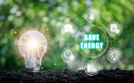 Téléchargez les photos : Concept d'économie d'énergie, ampoule sur le sol avec icône d'économie d'énergie sur écran virtuel. - en image libre de droit