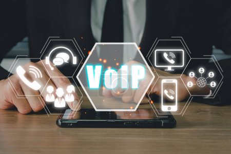 Foto de VoIP, concepto de telecomunicaciones de voz sobre IP, mano de la persona de negocios usando el teléfono inteligente con el icono de VoIP en la pantalla virtual. - Imagen libre de derechos