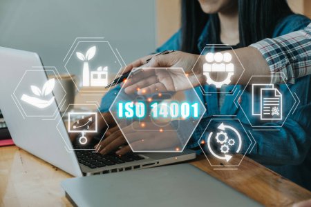 ISO 14001 zertifiziertes Konzept für Umweltmanagementsysteme, Ingenieur-Team arbeitet am Schreibtisch mit ISO 14001-Symbol auf virtuellem Bildschirm.