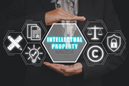 Concepto de propiedad intelectual, Businesswoman mano sosteniendo icono de propiedad intelectual en la pantalla virtual.