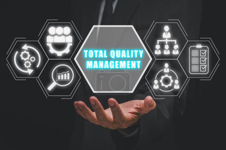 Téléchargez les photos : Concept de gestion de la qualité totale, Businessman main tenant icône de gestion de la qualité totale sur écran virtuel. - en image libre de droit