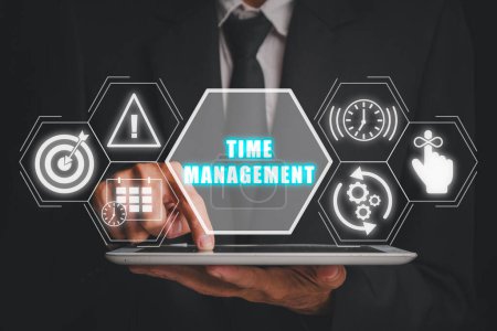 Téléchargez les photos : Concept de gestion du temps, Homme d'affaires utilisant une tablette numérique avec icône de gestion du temps sur écran virtuel. - en image libre de droit
