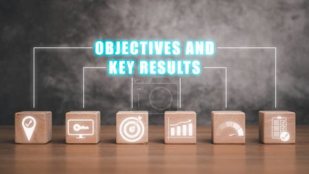 Photo for Objectives and key results concept, Wooden block on wooden desk with objectives and key results icon on virtual screen, Target, vision, objective, framework, key result, quarter, benefits, evaluation. - Royalty Free Image