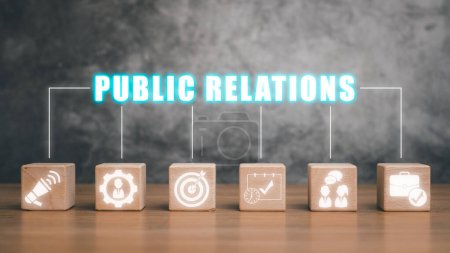Foto de Concepto de relaciones públicas, Bloque de madera en el escritorio con el icono de relaciones públicas en la pantalla circular. - Imagen libre de derechos