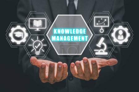 Foto de Concepto de gestión del conocimiento, Empresario mano sosteniendo icono de gestión del conocimiento en la pantalla virtual. - Imagen libre de derechos