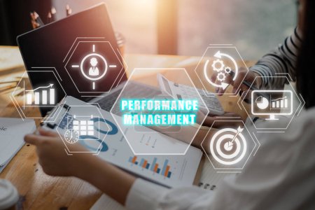 Performance-Management-Konzept, Business-Team analysiert Einkommenstabellen und Diagramme auf Bürotisch mit Performance-Management-Symbol auf virtuellem Bildschirm.
