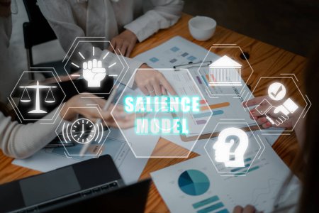 Salience-Modell-Konzept, Business-Team analysiert Einkommenstabellen und Diagramme auf Bürotisch mit Salience-Modell-Symbol auf virtuellem Bildschirm.