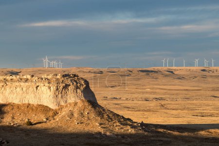 Ein Hintergrund von Windturbinen, die aktiv Strom auf den Pawnee National Grasslands in den Hochebenen des Nordostens Colorados erzeugen. Eine dramatische Landschaft der Ebenen Colorados kann in der Pawnee Buttes Area besichtigt werden.