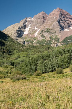 Foto de 14,163 Ft. Maroon Peak y 14,019 Ft. North Maroon Peak son las famosas campanas granate, que son un destino para escaladores y excursionistas para ver el majestuoso paisaje de la zona salvaje de campanas granate en el centro de Colorado. - Imagen libre de derechos