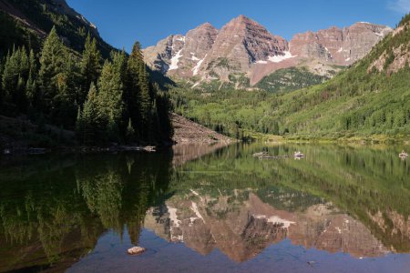 Photo for The Maroon Bells are reflected with the stillness of morning light on Maroon Lake, which is visited by tourist from all over the world to this famous destination. - Royalty Free Image