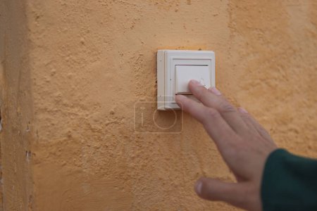 Female hand presses the doorbell button on the street close-up .there is a place for the inscription. High quality photo