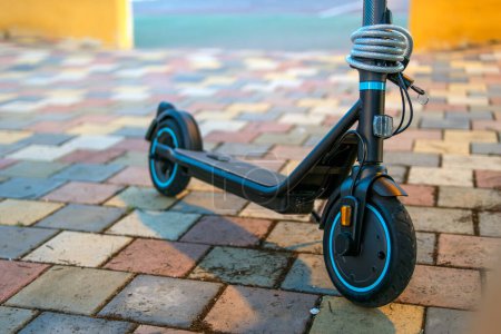 A close-up of the wheels of an electric scooter on the pavement in the park, showcasing modern urban mobility and eco-friendly transportation.