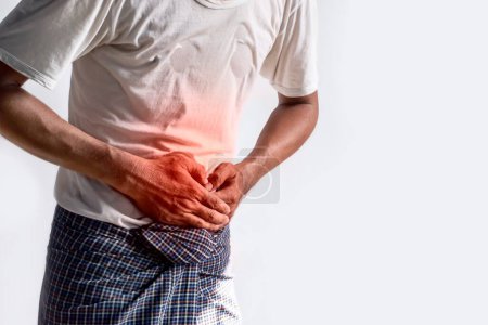 Photo for Asian young man suffering from upper abdominal pain. It can be caused by stomach ache, enteritis, colitis, appendicitis, hepatitis, pancreatitis, food poisoning, irritable bowel syndrome, etc. - Royalty Free Image