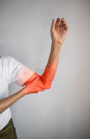 Photo for Pain in the arm of Southeast Asian old man. Concept of elbow and forearm pain, injury or muscle problem. - Royalty Free Image