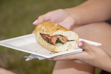 Téléchargez les photos : Les mains de femme tenant un sandwich chorizo - en image libre de droit