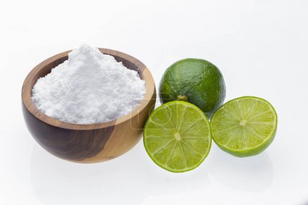 Baking soda in wooden container and lime, isolated on white