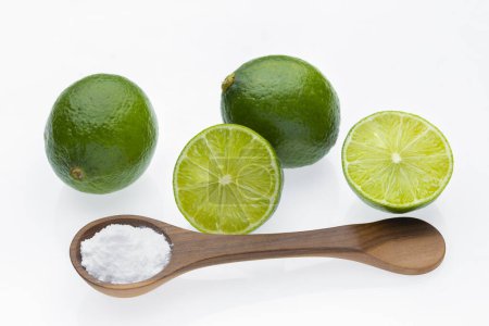 Baking soda in wooden container and lime, isolated on white