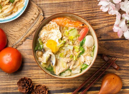 Téléchargez les photos : Nouilles Sacha Hot Pot originales avec tomate et baguettes servies dans un plat sur une table en bois vue sur la nourriture chinoise - en image libre de droit