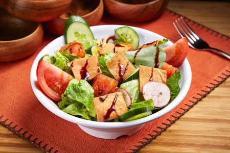 Téléchargez les photos : Salade Fattoush fraîche avec tomate, concombre et feuille verte servie dans un bol isolé sur la table vue de côté de la nourriture du Moyen-Orient - en image libre de droit