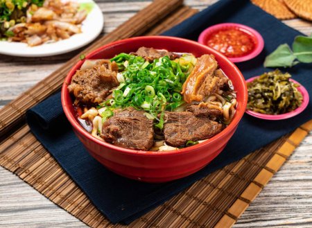 Téléchargez les photos : Nouilles de bœuf à l'oignon vert et sauce chili servies dans un bol isolé sur la table de la nourriture taïwanaise - en image libre de droit