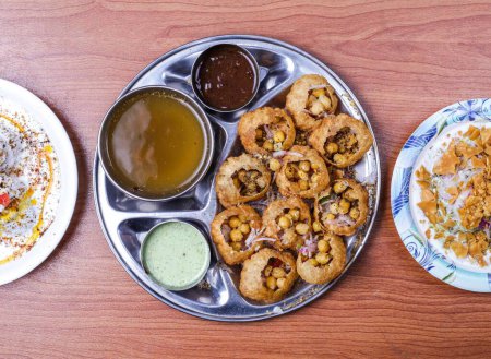 Foto de Channa papri chat masala, dahi baray y pani puri o gol gappay con raita, salsa dulce y agua picante servido en plato aislado en la vista superior de la mesa de comida india y pakistaní - Imagen libre de derechos