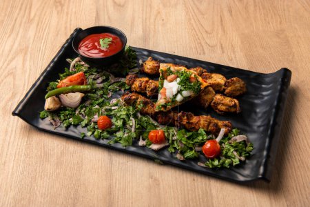 Téléchargez les photos : Saumon Shish Tawook épicé avec salade et sauce tomate servi dans un plat isolé sur la table vue sur la nourriture arabe - en image libre de droit