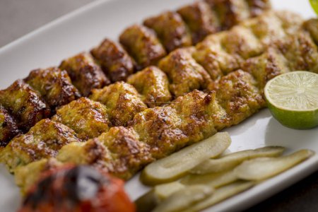Foto de Jujeh kebab kofta con lima servida en plato aislado sobre fondo gris vista superior de comida árabe - Imagen libre de derechos