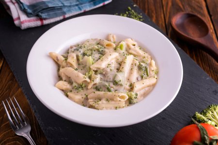 Photo for White creamy pasta served in dish top view on dark background american fast food - Royalty Free Image