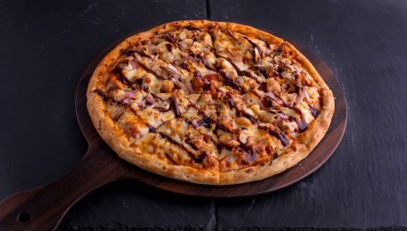 BBQ CHICKEN pizza isolée sur planche à découper vue du dessus sur fond sombre italien fast food